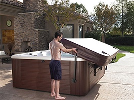 a man easily opens the cover on his hot tub by himself