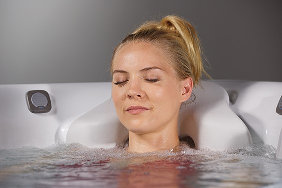 a woman uses warm water hot tub therapy as a natural sleep aid