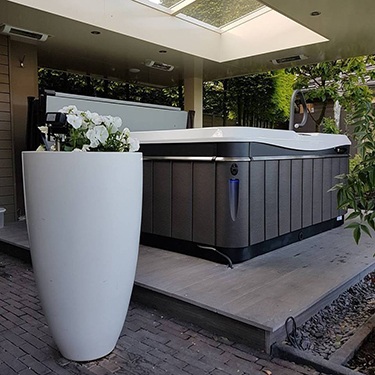 a utopia hot tub sits under a portico for protection from the weather