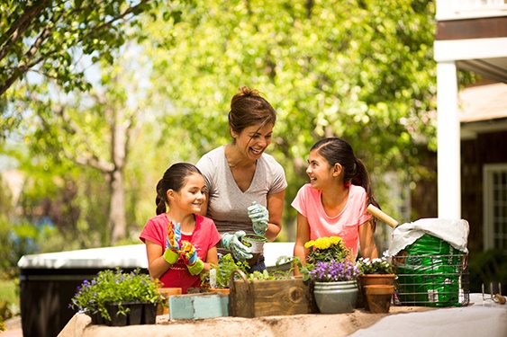 a family enjoys some gardening with their energy efficient hot tub in the background