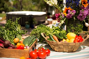 a pile of fresh vegetables cover a table with the image of a hot tub in the background