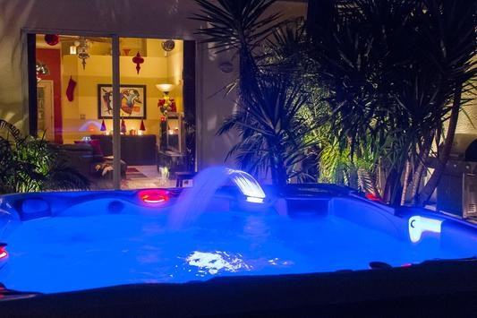 A customer submitted image of their backyard and their own hot tub colored lighting choice of blue