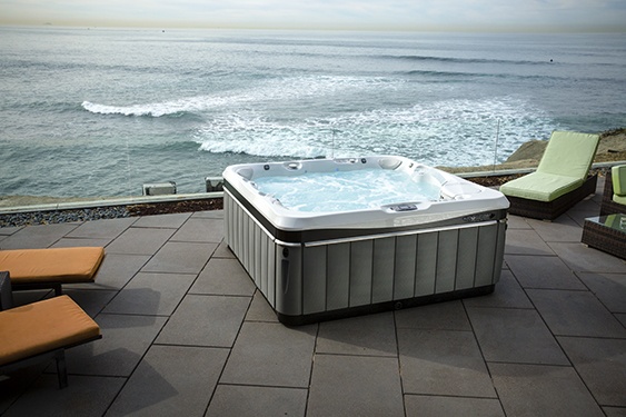 a utopia tahitian hot tub jacuzzi sits perched on a cliffside patio overlooking the ocean